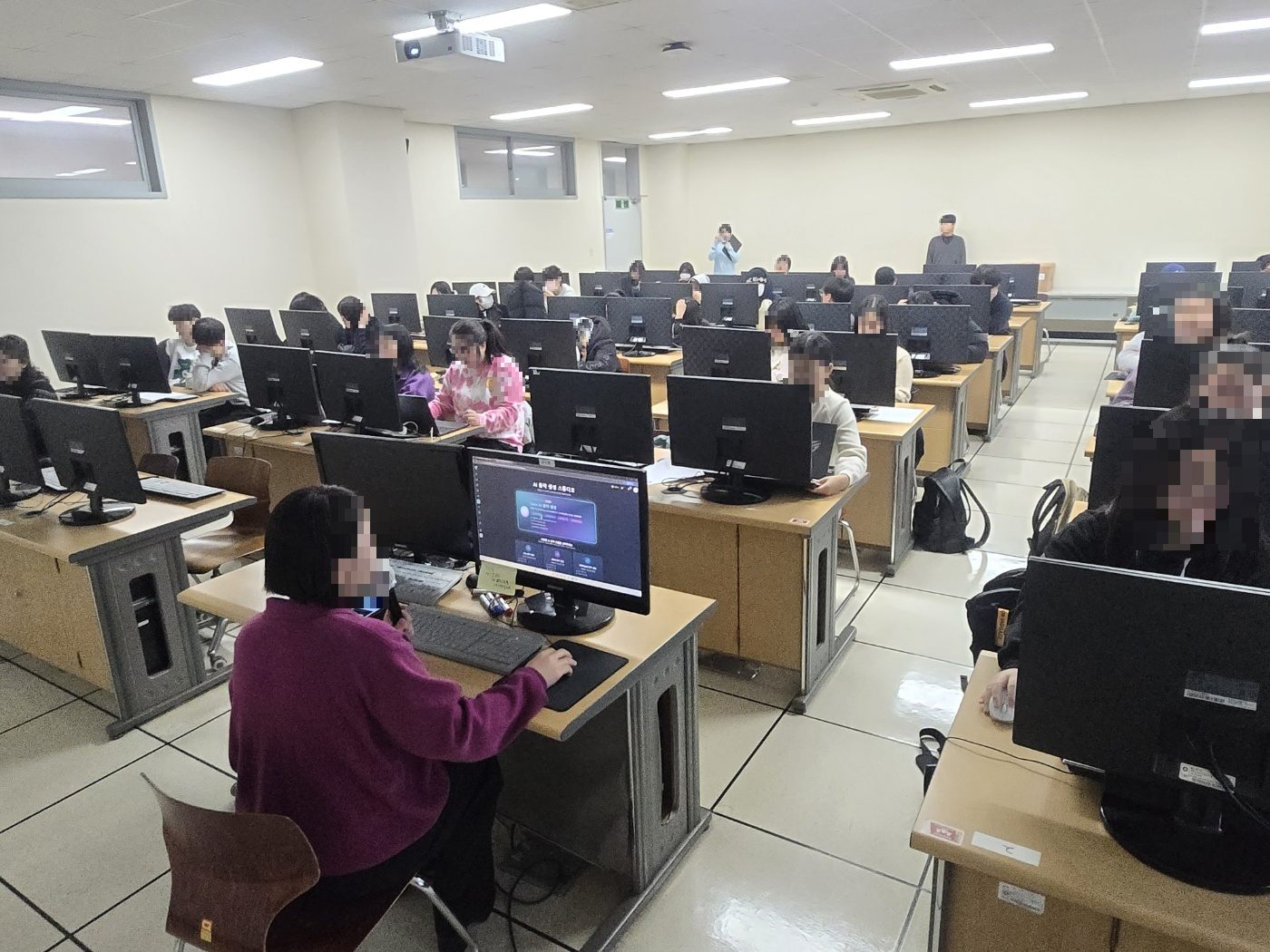 강사가 대형 화면 앞에서 진행 중인 실제 강의실